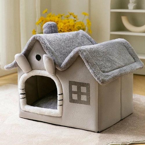 Cat house with a gray roof and beige body on a light surface.
