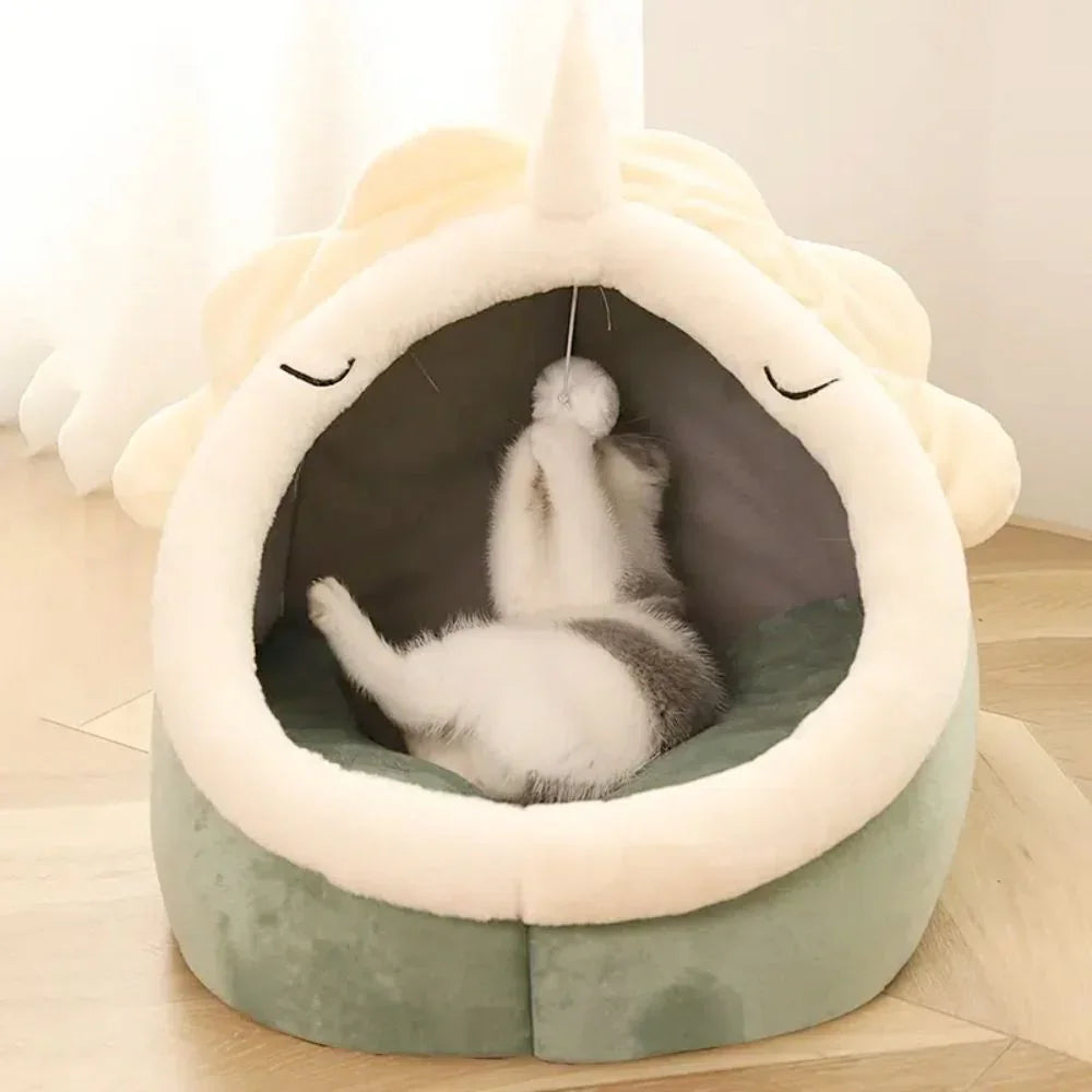 Orange tabby cat sleeping comfortably inside dinosaur pet cave bed